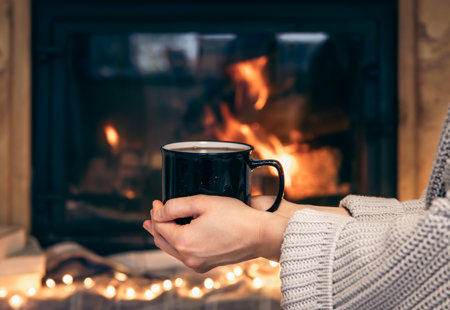 Cup With Hot Drink Female Hands Blurred Fireplace Background