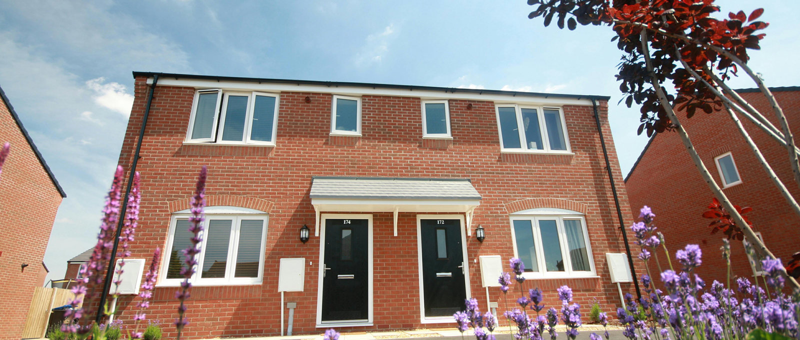 Photograph of a modern semi-detached house with flowers in the foreground