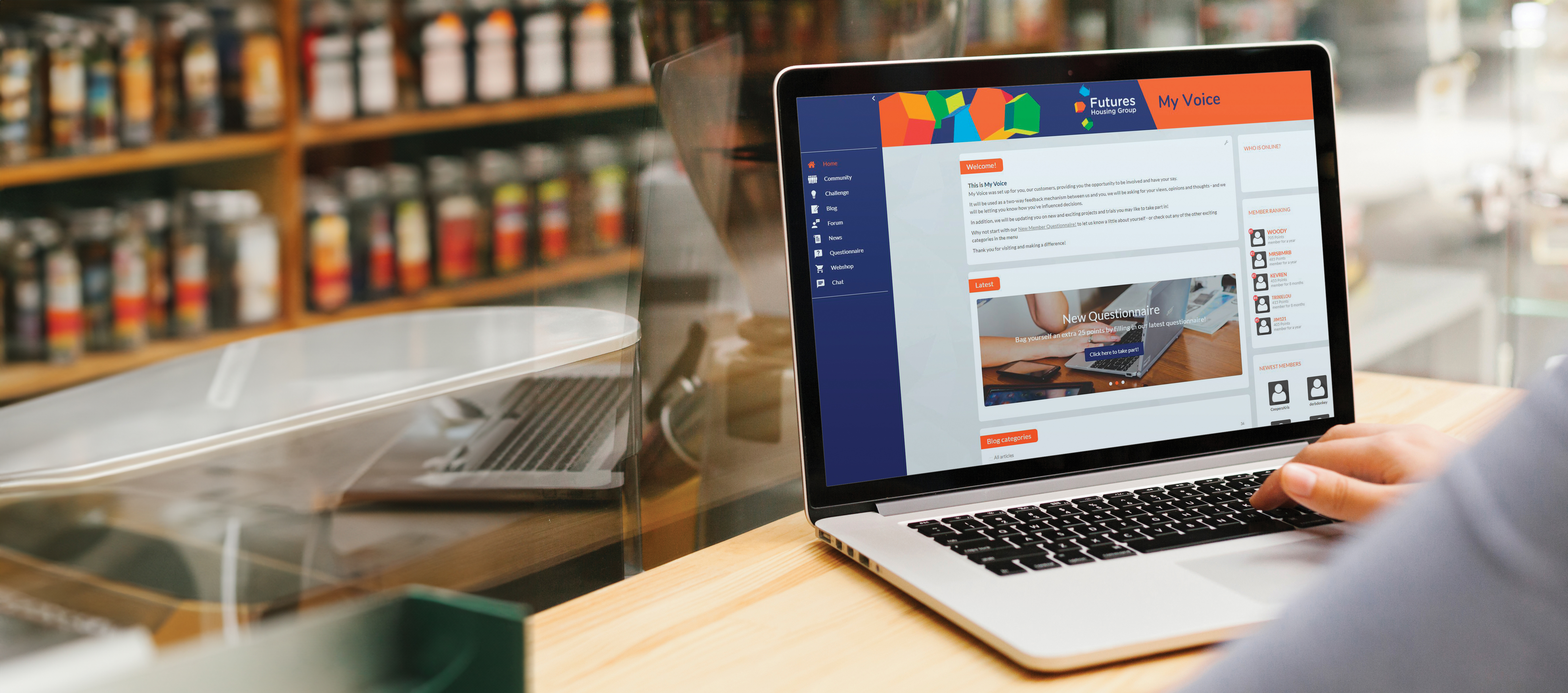 Close up photo of a laptop on a surface taken from over the shoulder of the person using it. Futures' My Voice customer platform can be seen on the screen.